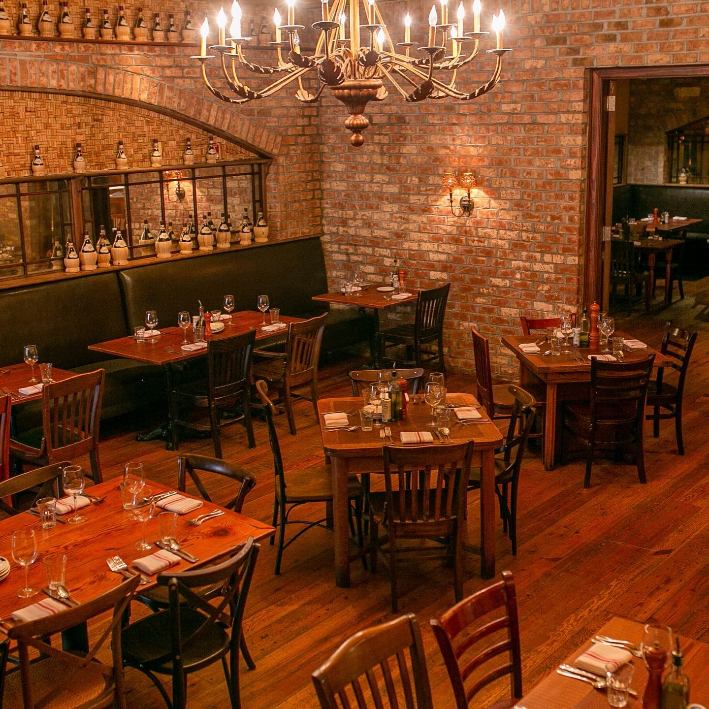 The brick dining room with its chandelier, set for dinner
